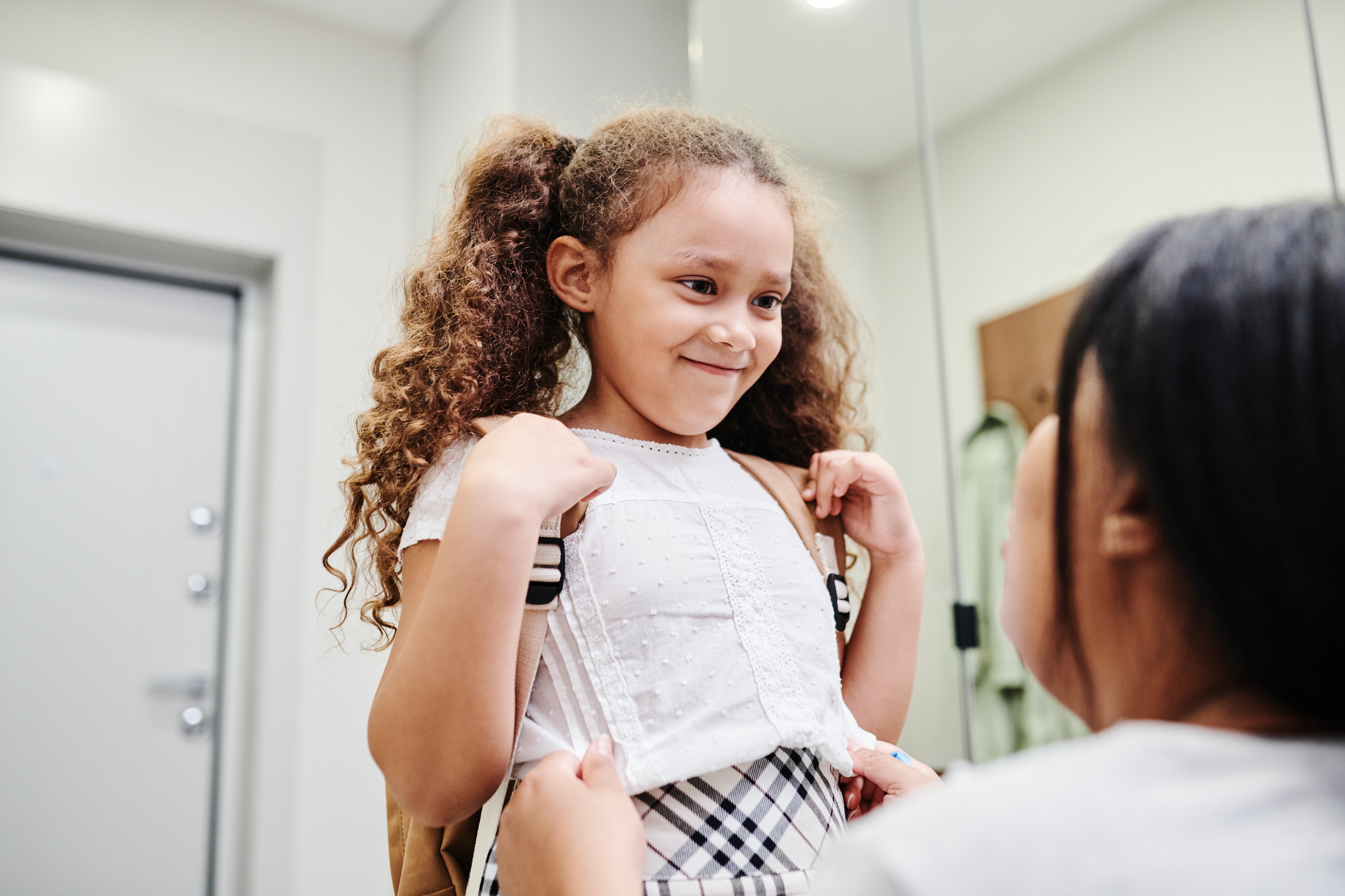 Mom getting daugther ready for school. 