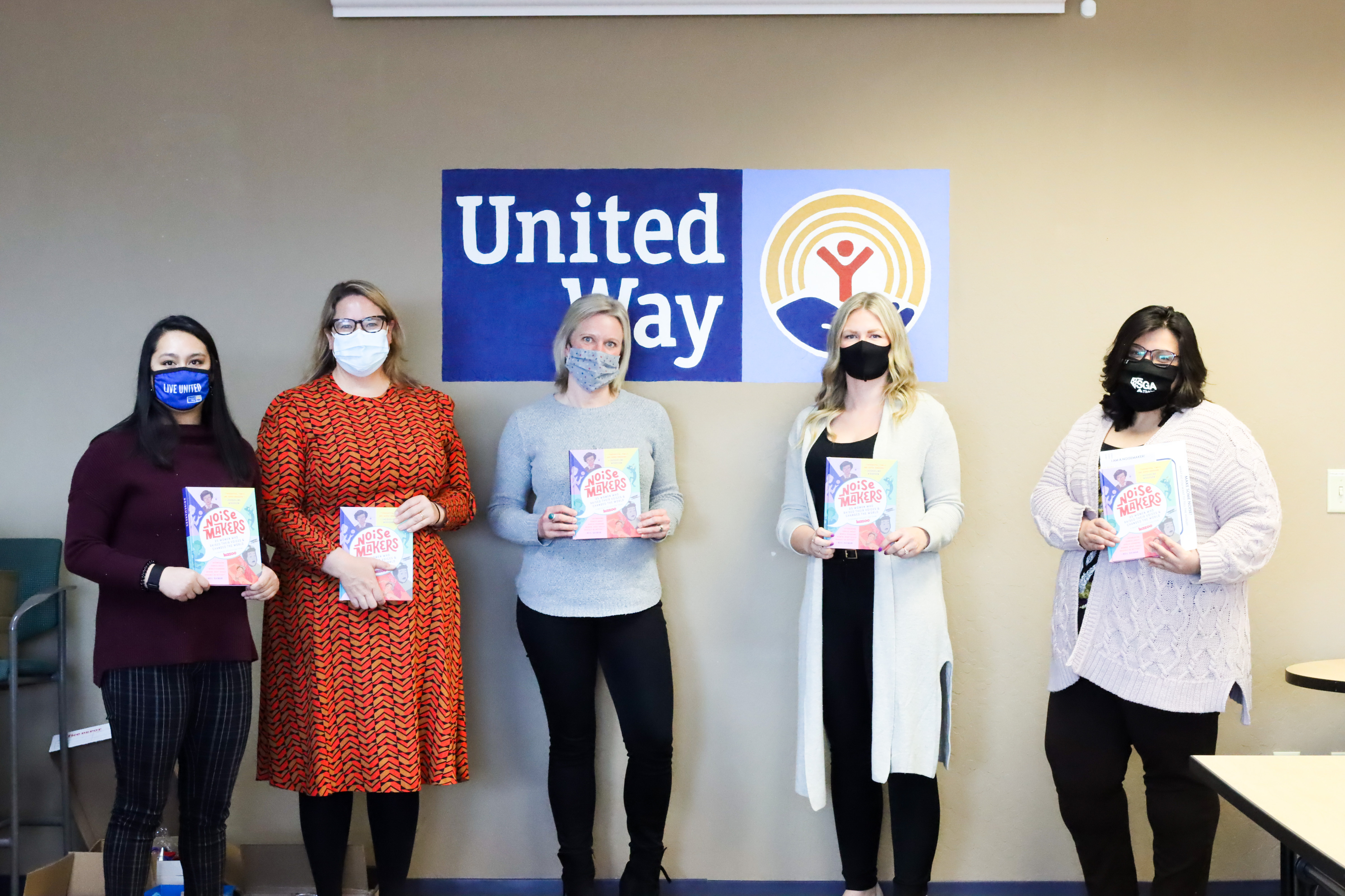 Image of Women United members holding books. 