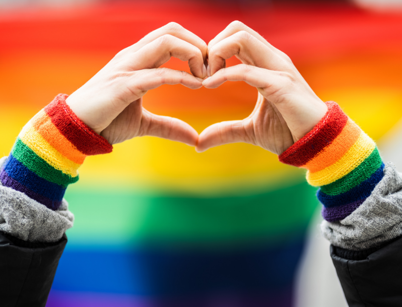 Hands forming a heart with rainbow colors everywhere. 