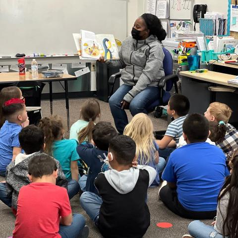 Volunteer reading to classroom.