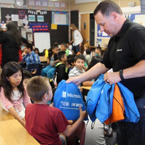 Volunteer handing out books to local students. 